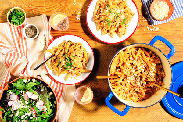 A pot of Chicken Chili Penne next to a green salad.