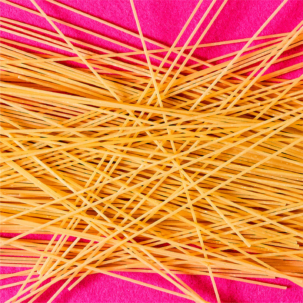 Spaghetti noodles on a pink background