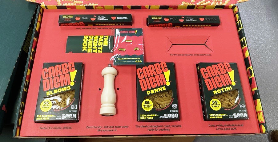 Carbe Diem pasta boxes with a pepper grinder on a red background
