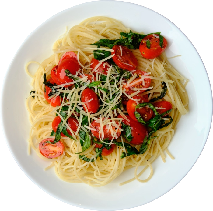 Spaghetti dish with cherry tomatoes and spinach on a white plate